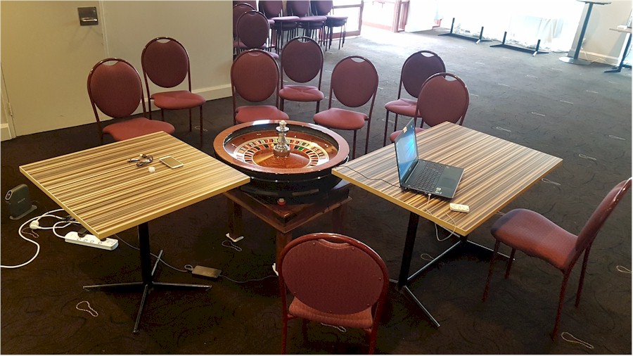 Group of chairs around roulette wheel.