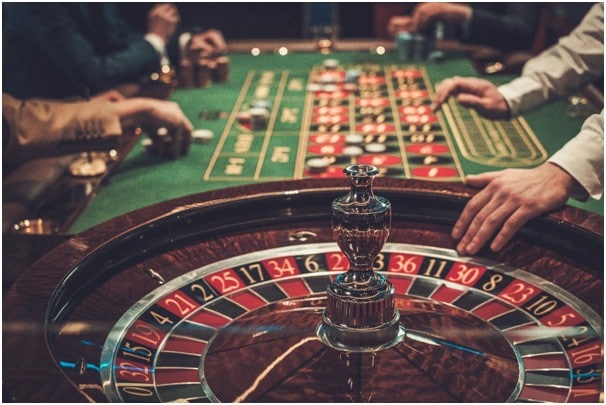 Dealers hand on edge of roulette wheel